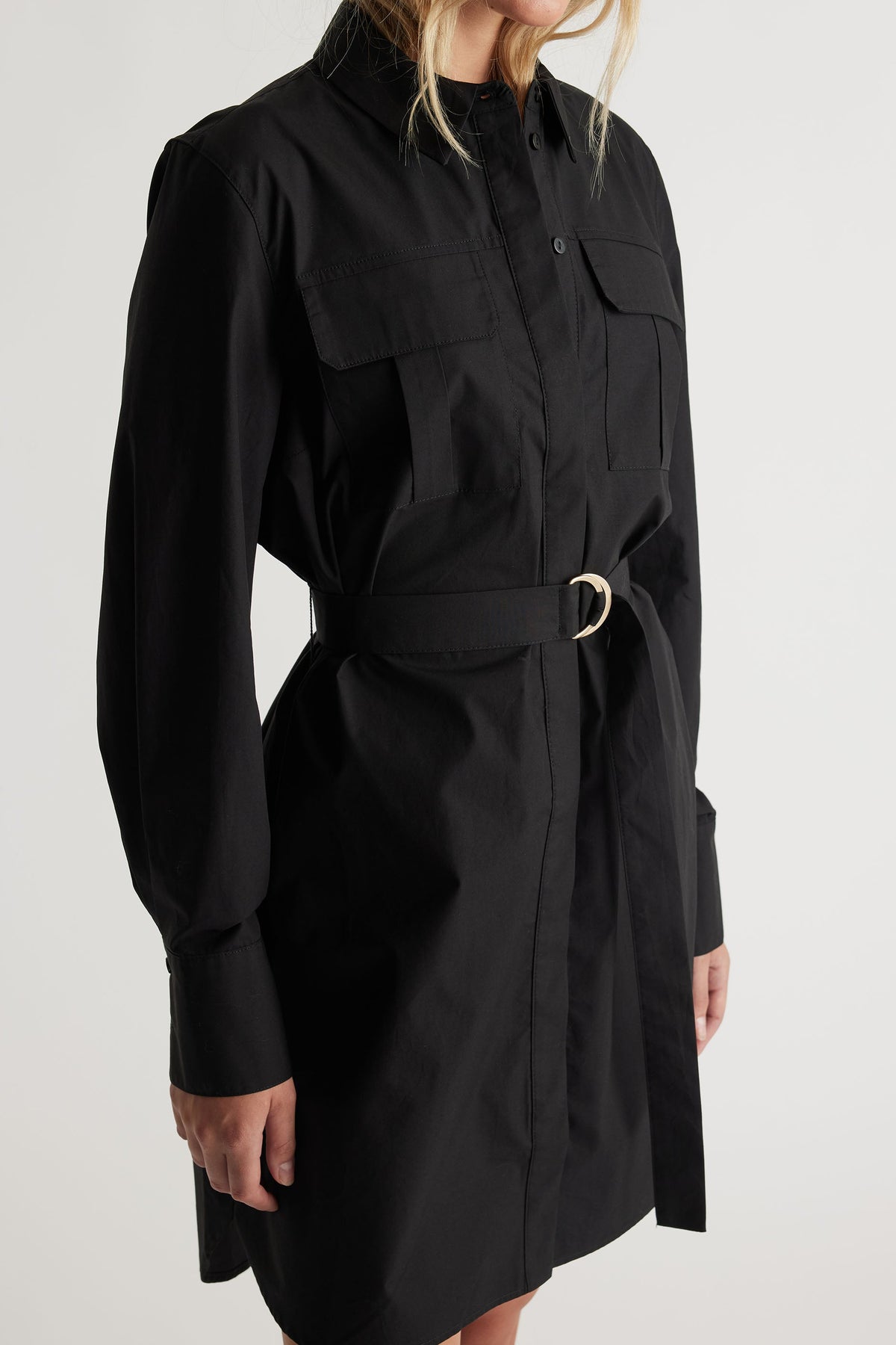 Black belted mini shirt dress with long sleeves and chest flap pockets for a modern, tailored look