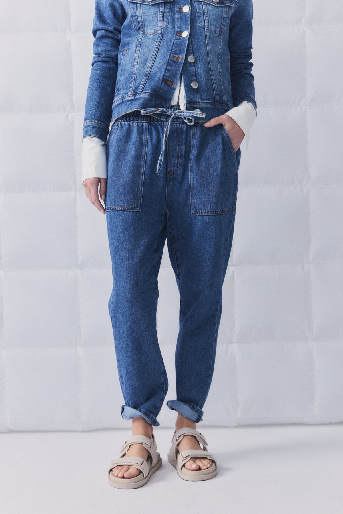 Relaxed fit blue denim joggers with drawstring waist, paired with a classic denim jacket for effortless casual style.