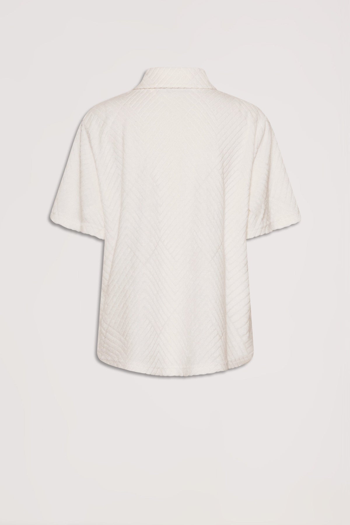 Back view of a short-sleeve terry shirt in a soft vanilla shade with subtle textured patterning.