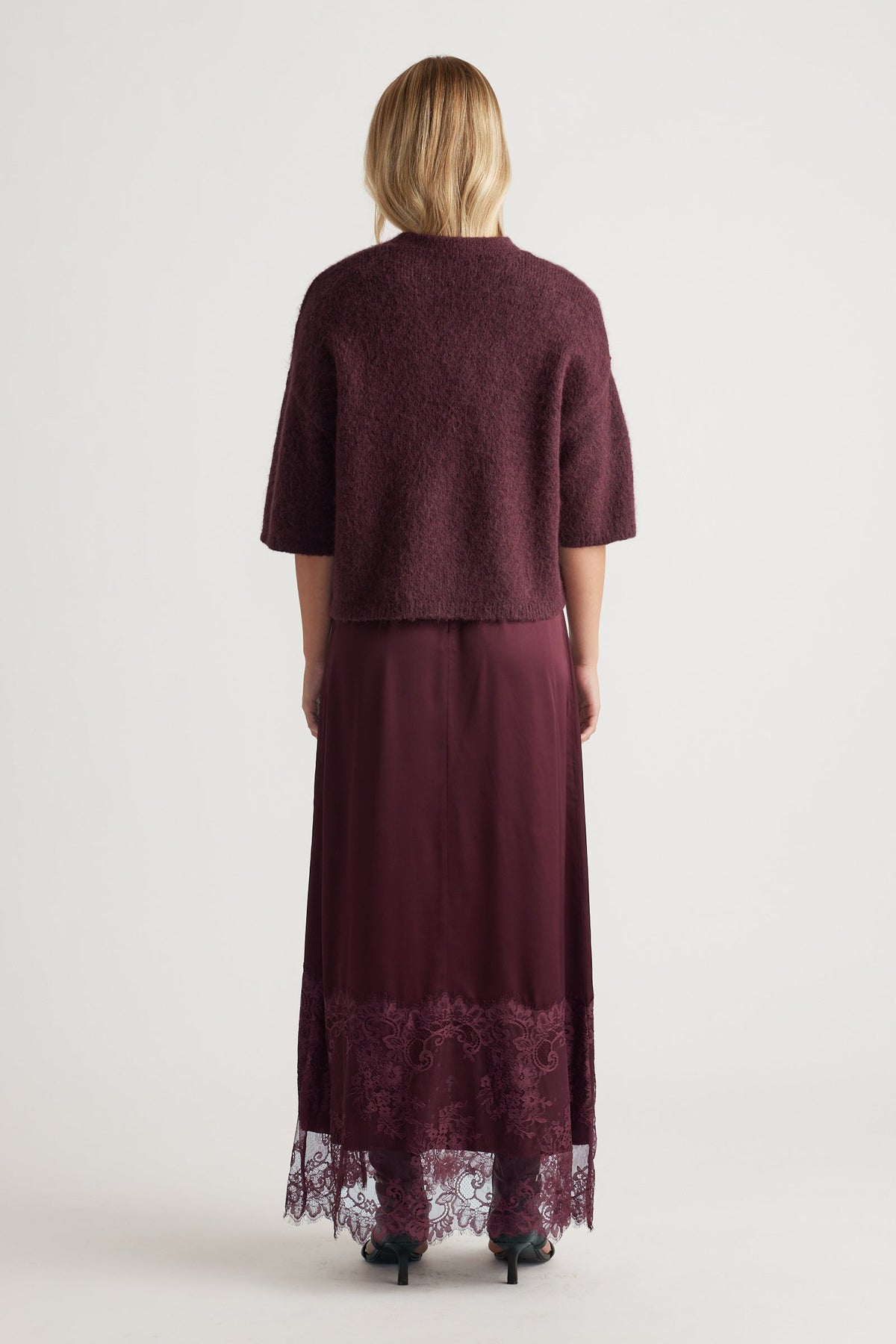 Woman shown from behind wearing a burgundy fluffy knit tee with elbow-length sleeves paired with a lace-hem maxi skirt