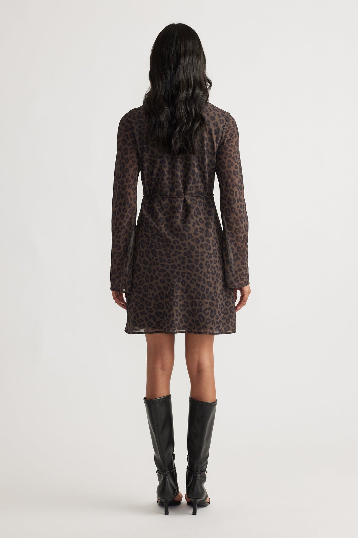 Chelsea Georgette Mini Dress in dark leopard print with long sleeves, styled with knee-high black boots by DECJUBA