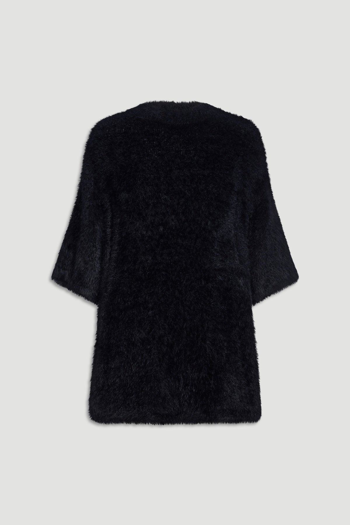 Back view of a soft black oversized knit tee with wide sleeves and a relaxed, cozy fit