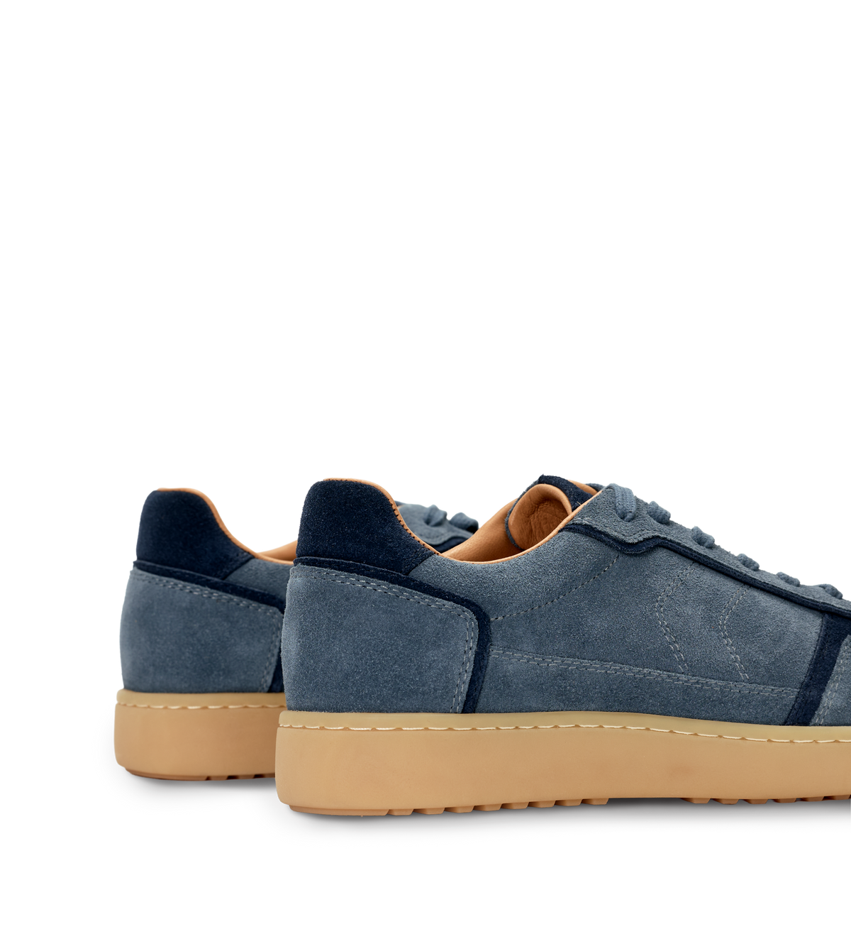 Blue suede sneakers with tan soles on a white background