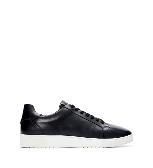 A black leather sneaker with lace-up closure, displaying the sole and the inner part of the shoe.