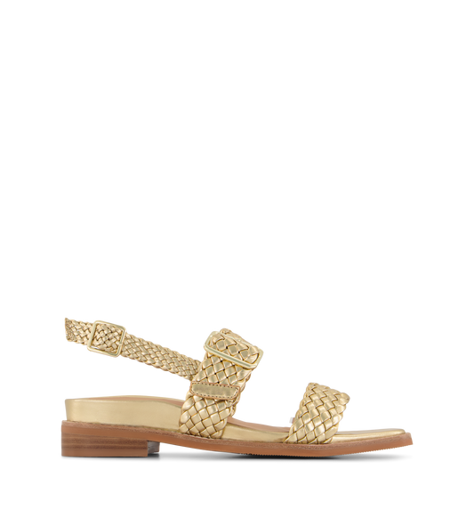 A gold leather sandal with adjustable mid-foot and slingback buckle strap, featuring a flat heel and gold hardware.