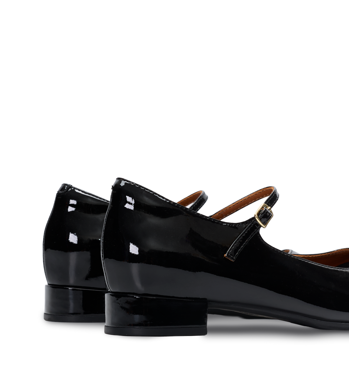 Black patent leather shoes with a strap on a white background