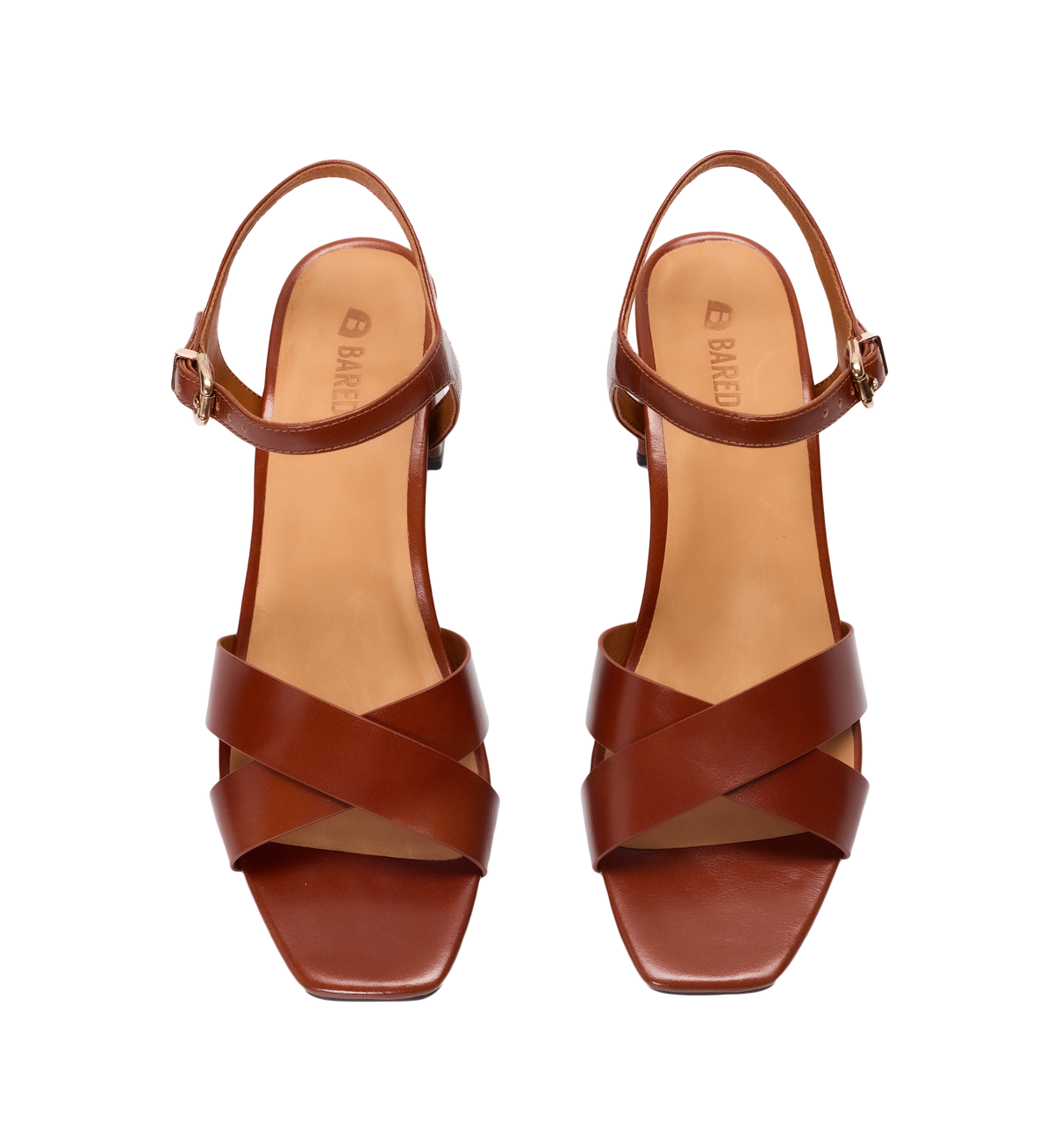 Pair of brown heels with criss-cross straps on a white background