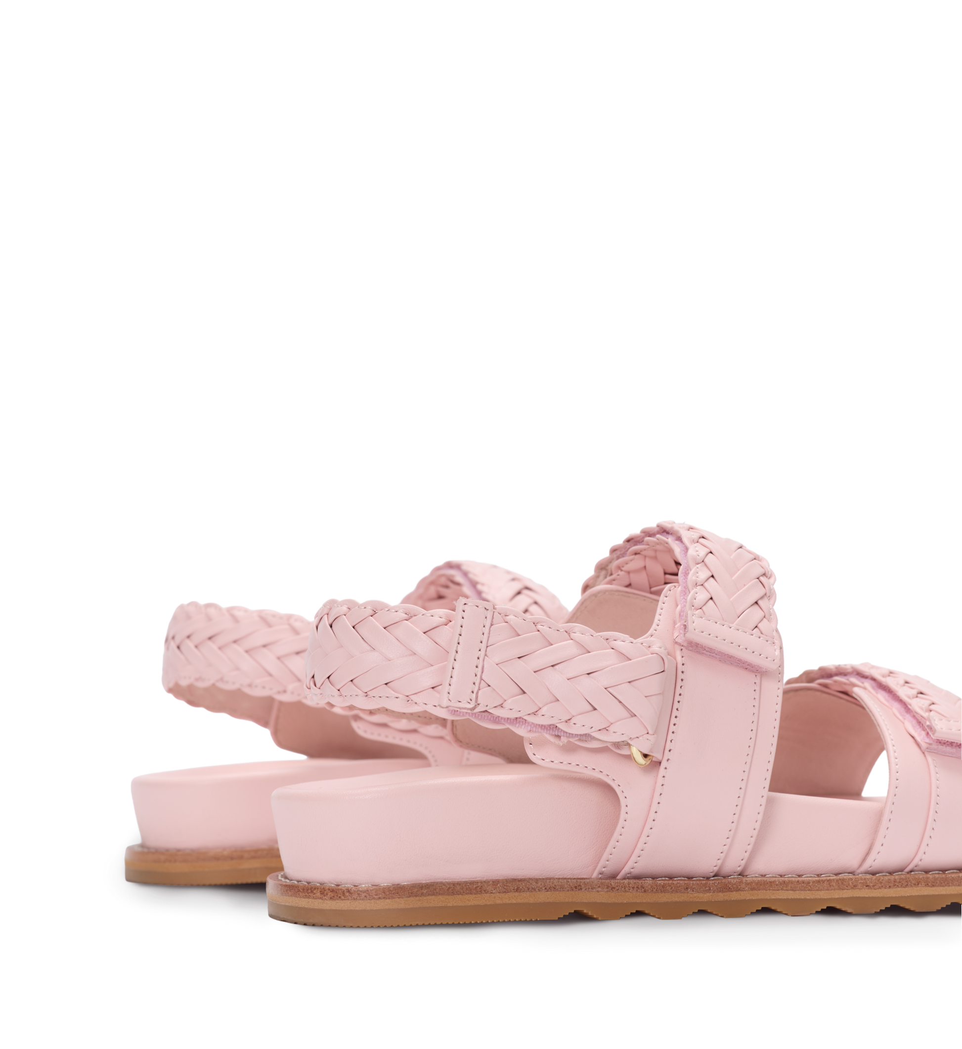 Pink sandals with woven design on a white background