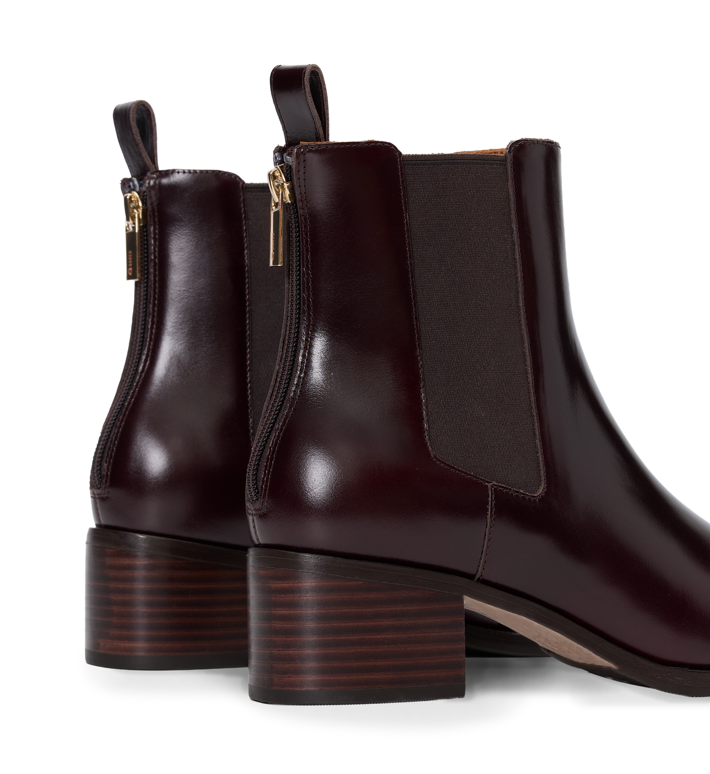 Pair of brown leather ankle boots with gold zippers on a white background