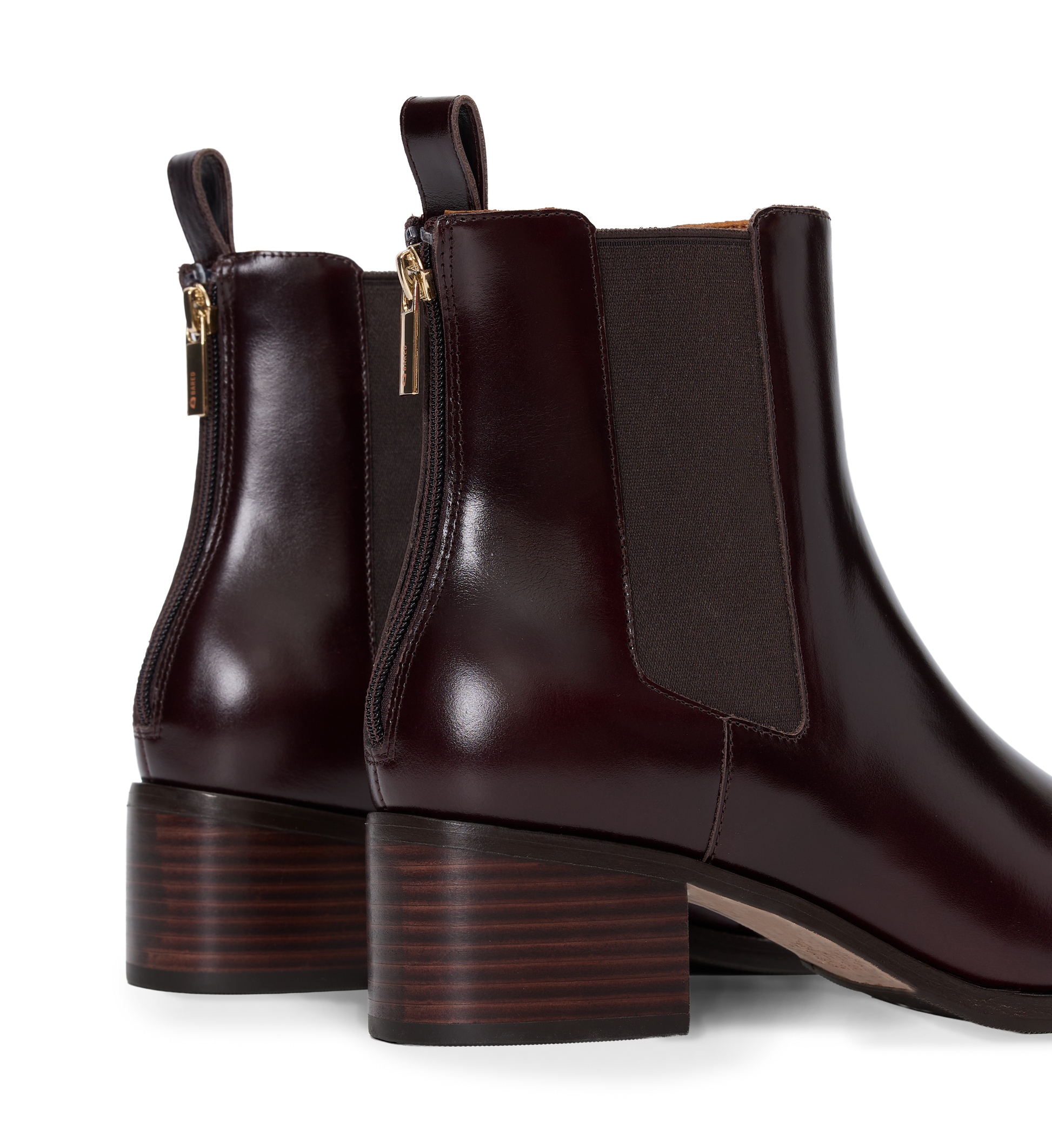 Pair of brown leather ankle boots with gold zippers on a white background