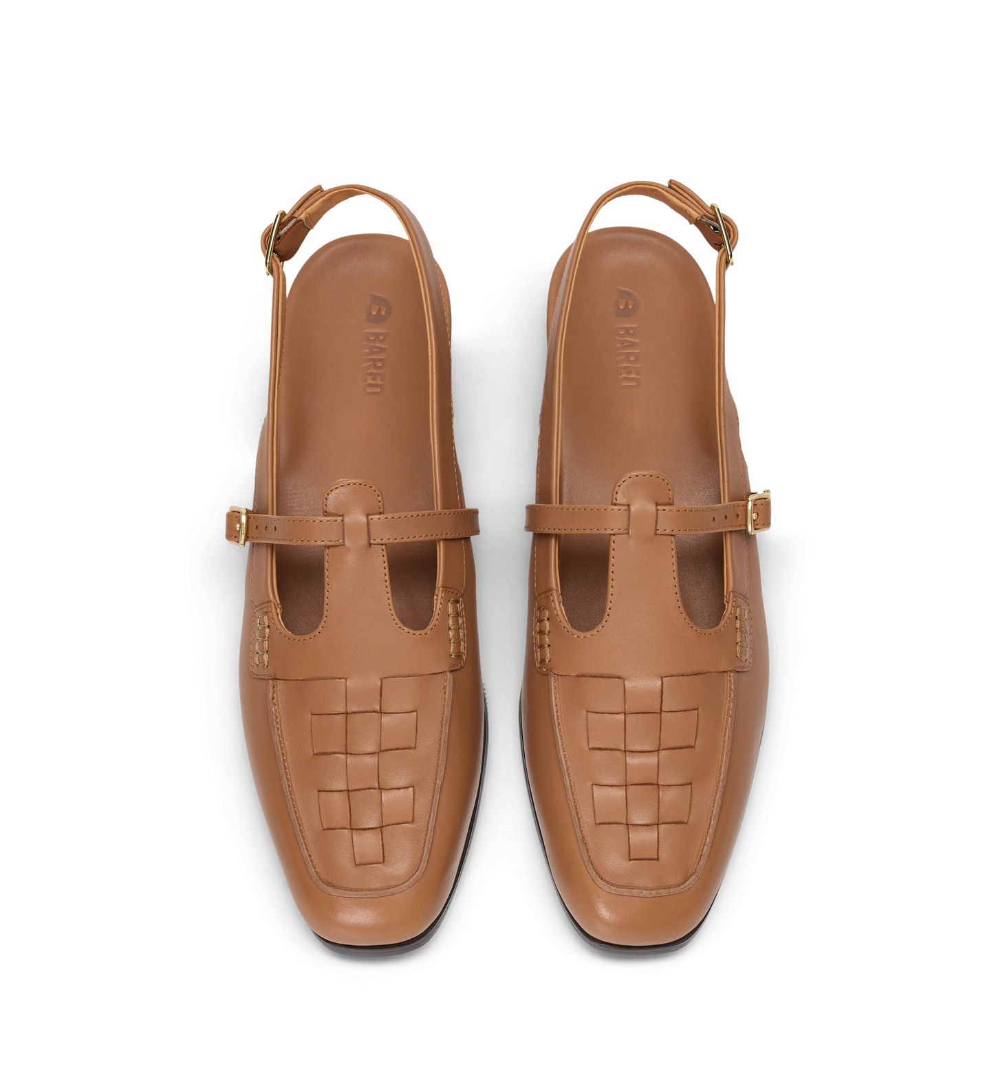 Pair of tan woven shoes with strap details on a white background