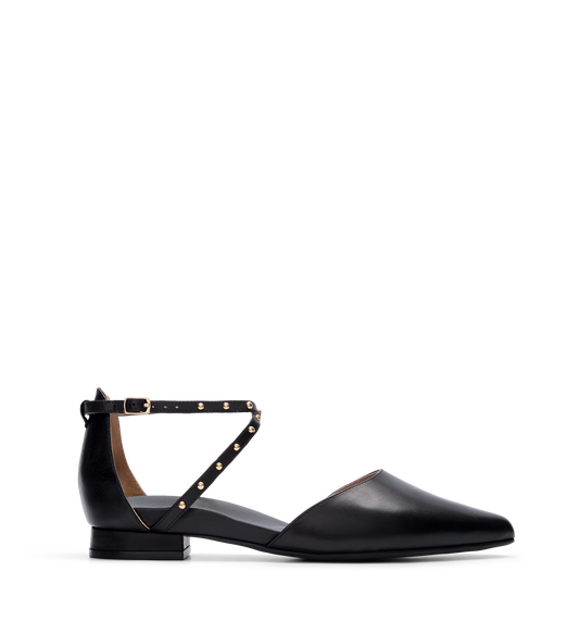 A single black leather flat shoe with an adjustable ankle strap and gold hardware.