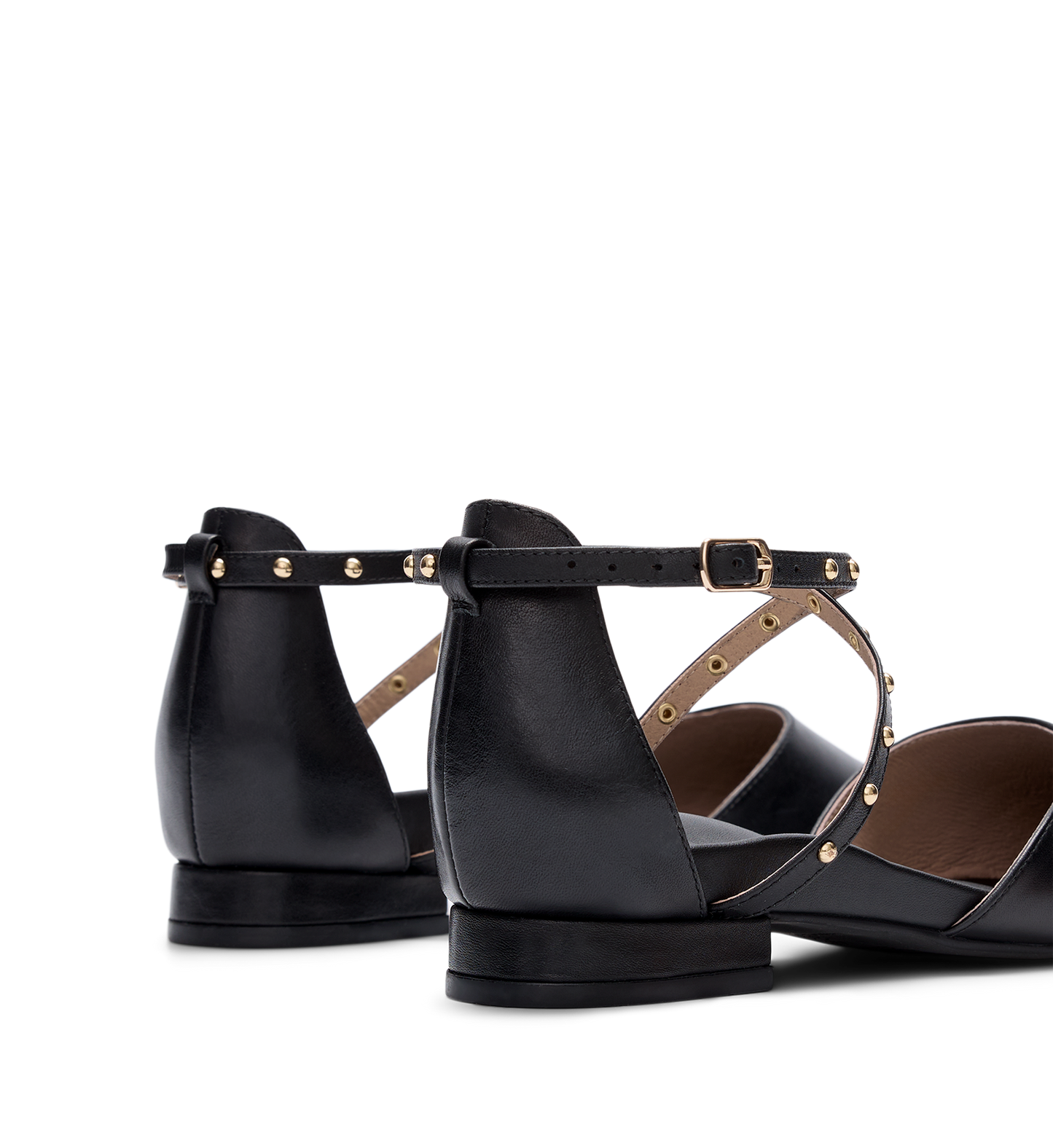 Black leather flats with gold accents on a white background
