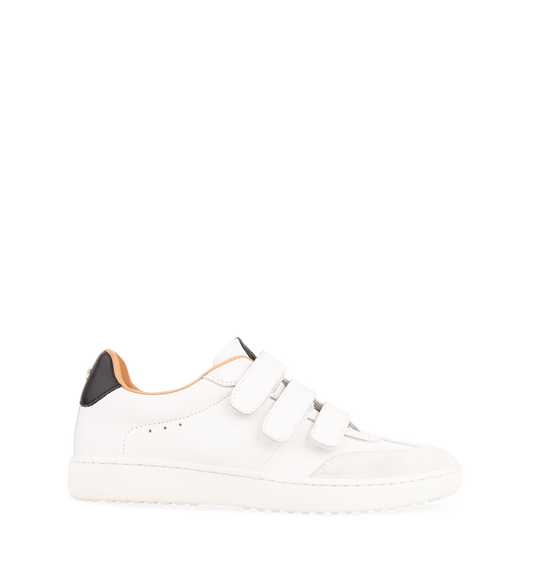 A white leather sneaker with hook and loop straps and a flat heel.