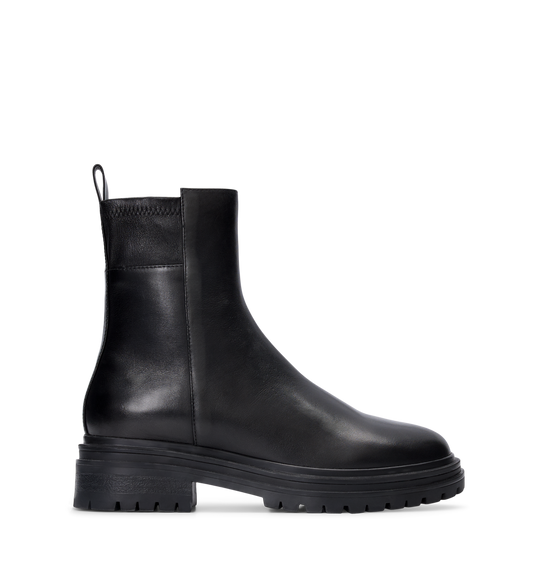 A black leather flat boot with a chunky rubber sole.