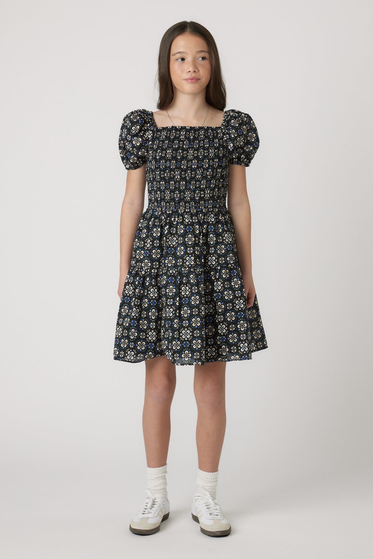 Girls Maude Mini Dress with short balloon sleeves and floral print, worn by model in portrait gallery position 1, 4060x6090px.