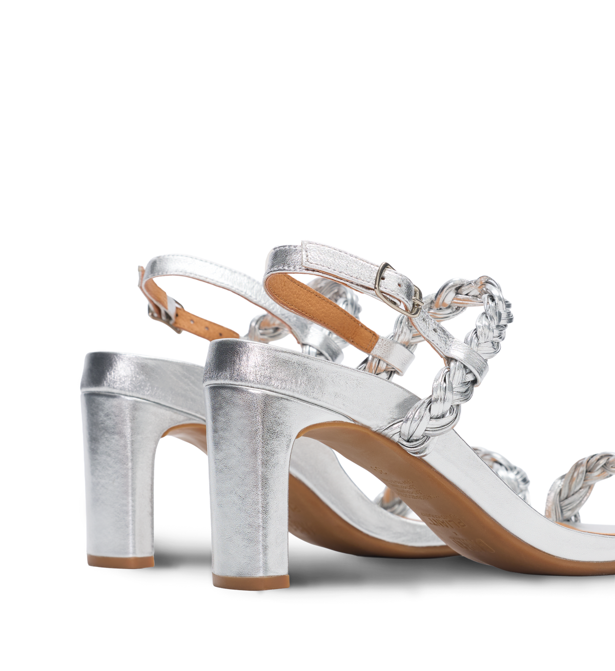 Silver high-heels with decorative straps on a white background