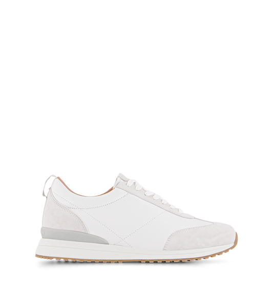 A white leather sneaker with lace-up closure and a flat heel.