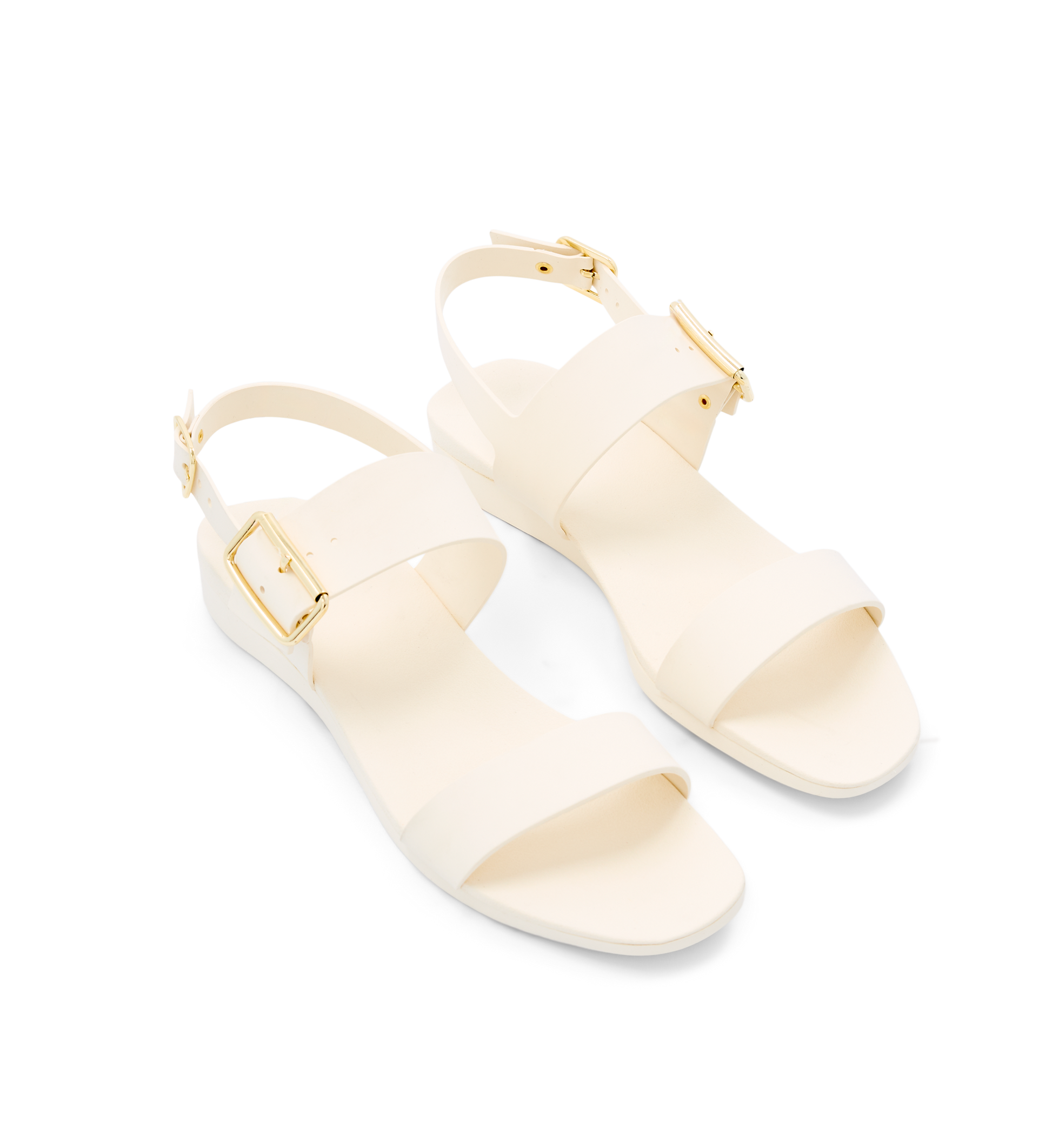 Pair of cream sandals with gold straps on a white background
