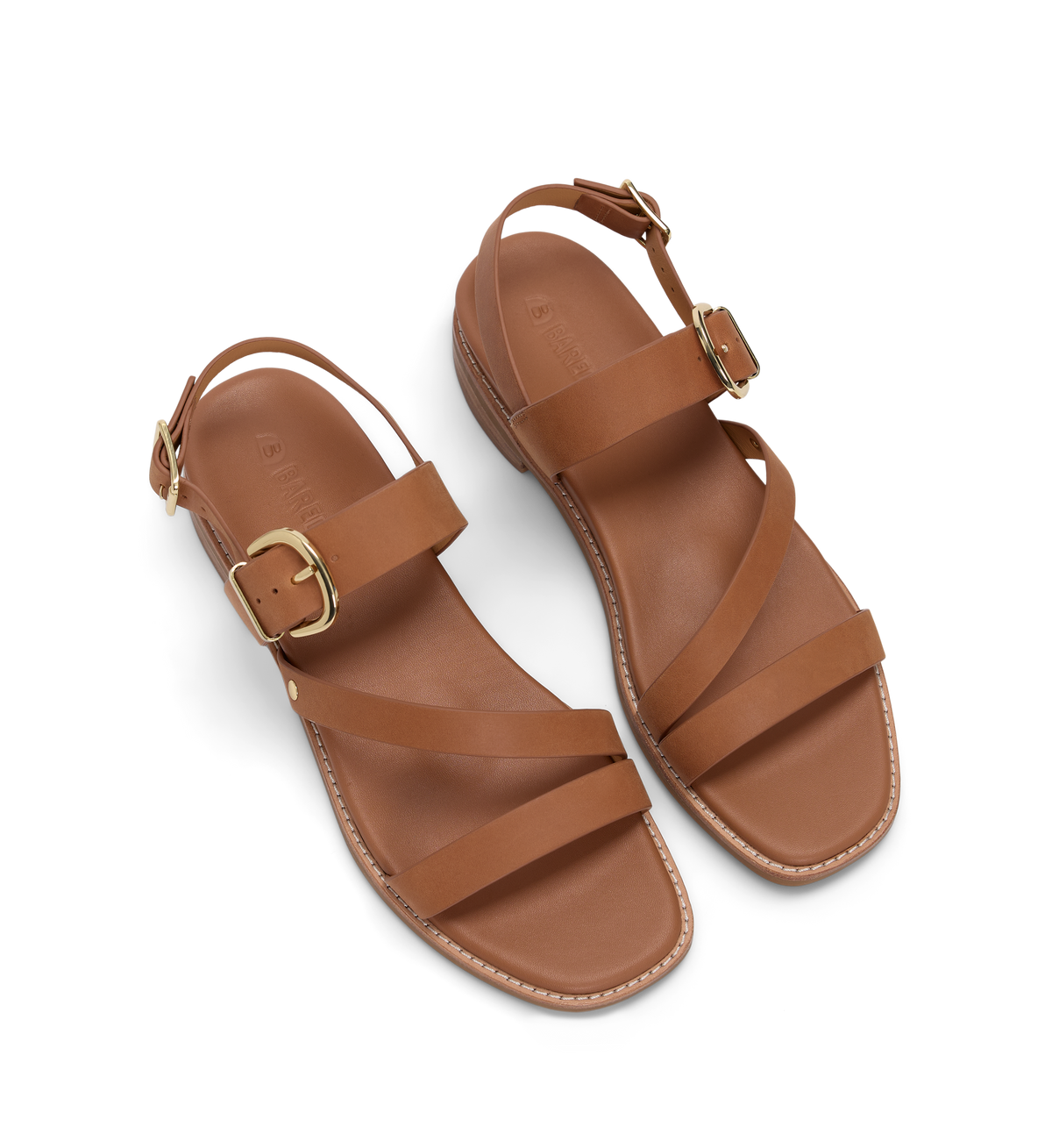 Pair of brown sandals with gold buckles on a white background